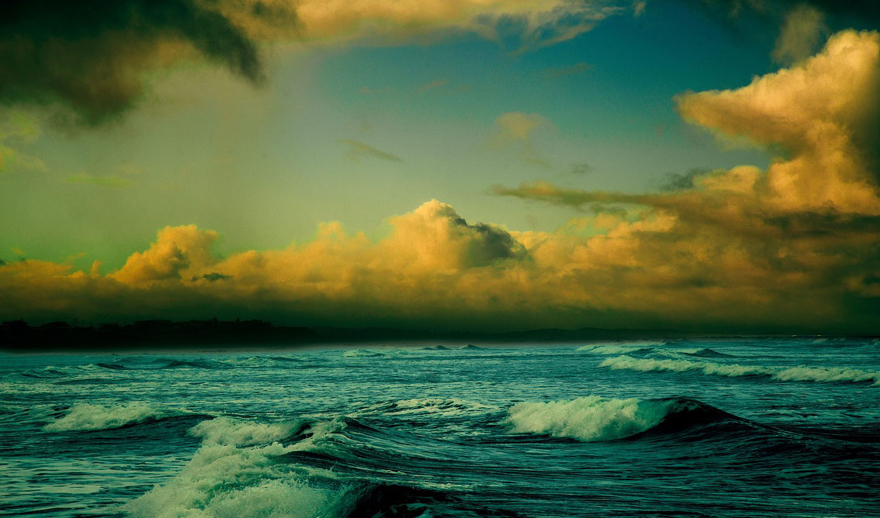 A dark ocean with yellow clouds